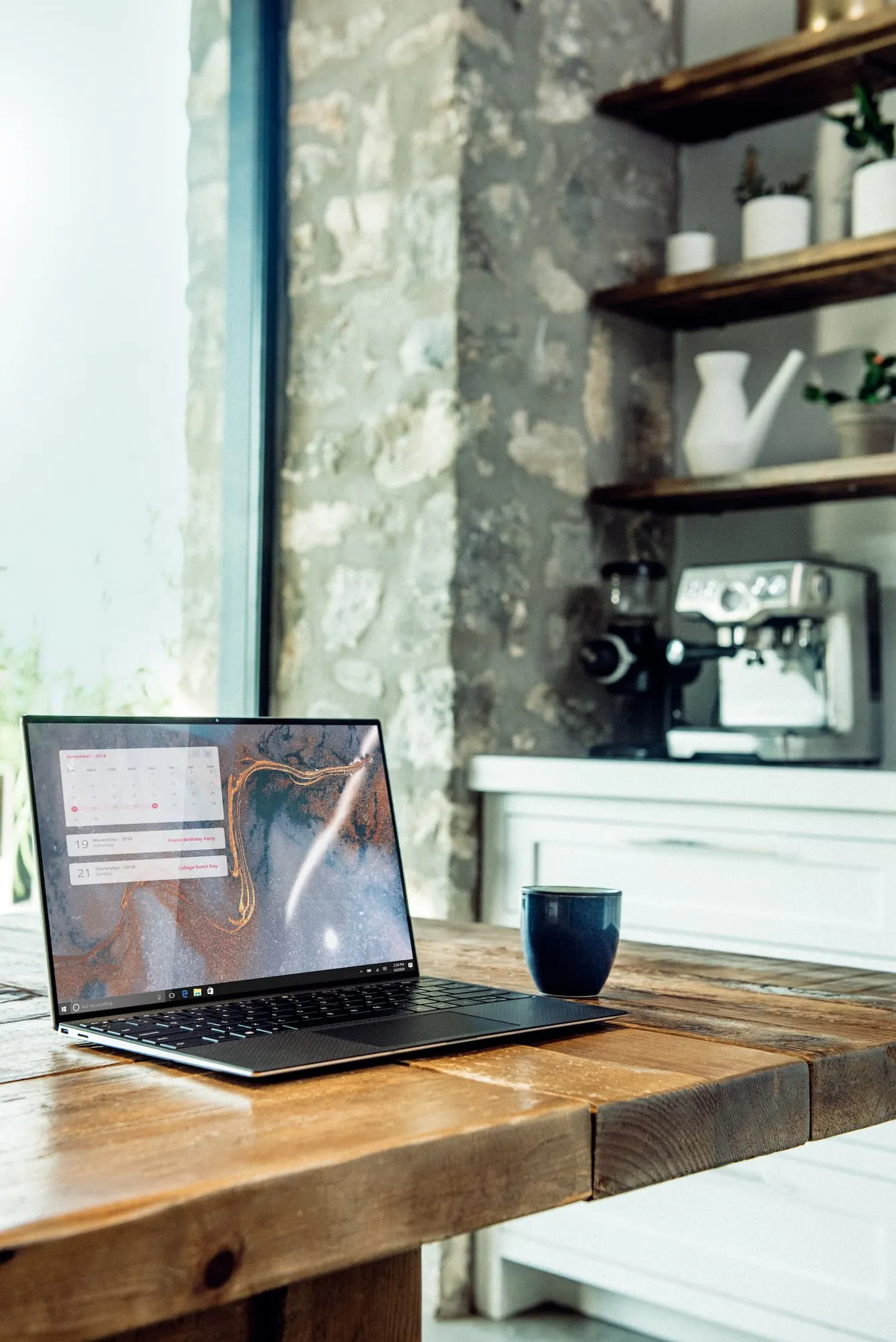 Laptop on a wooden table with coffee in the background